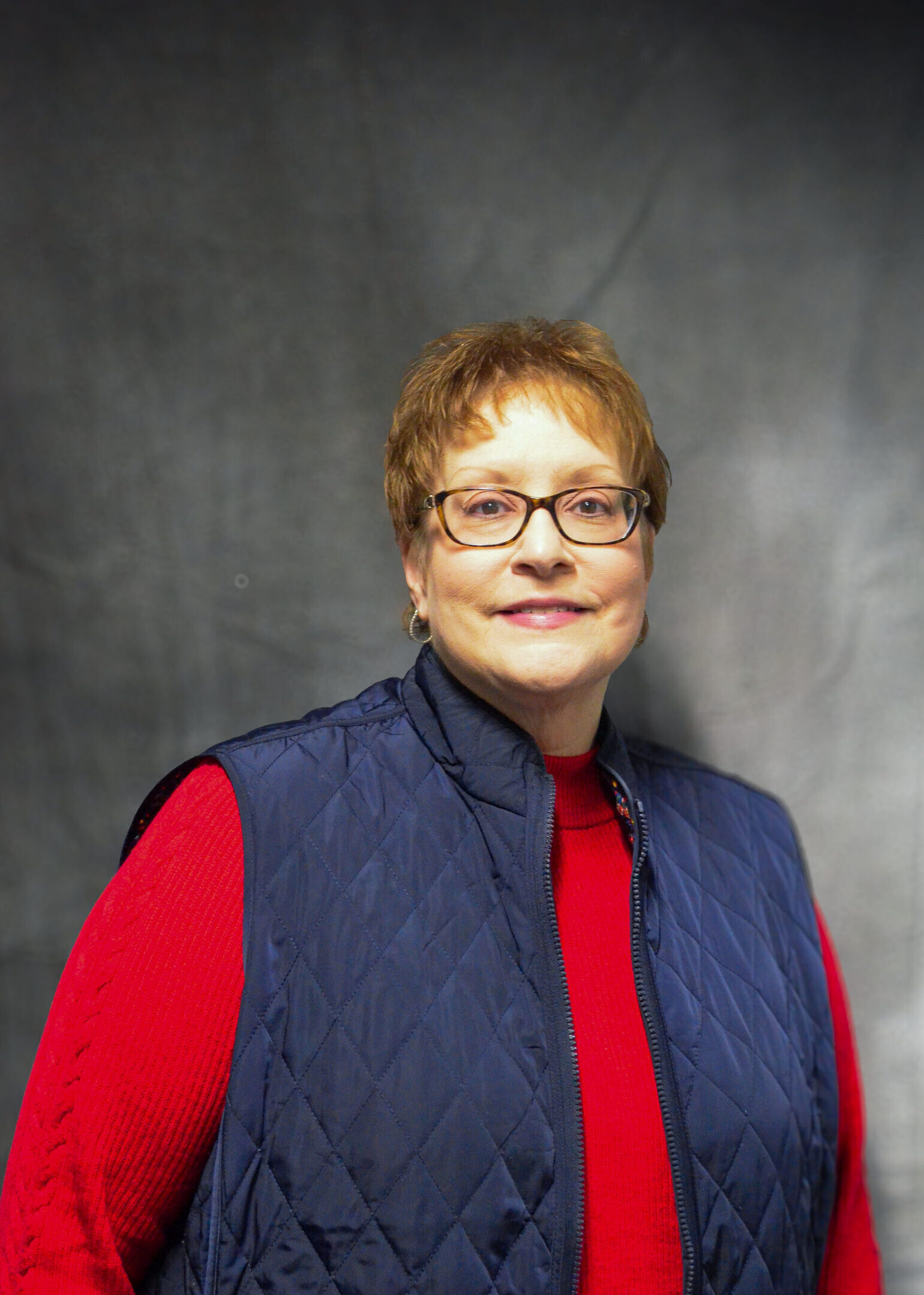 Female wearing red sweater and blue vest
